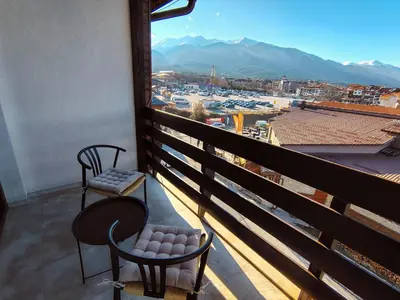 a balcony with two chairs and a view of a harbor at Great view studio Pirin Palace in Bansko