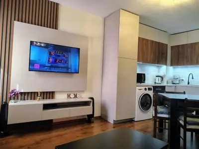 a living room with a tv on a wall at Great view studio Pirin Palace in Bansko