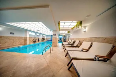 a hotel pool with lounge chairs and a swimming pool at ЕлеаНора, Смолянски езера EleaNora Smolyan lakes in Smolyan