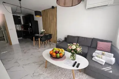 a living room with a couch and a table with a bowl of fruit at Delux 2 - Plovdiv Модерен апартамент до Стария град и Източната порта in Plovdiv