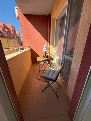 a balcony with a table and a chair and a window at Delux 2 - Plovdiv Модерен апартамент до Стария град и Източната порта in Plovdiv