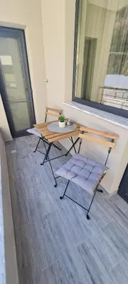 a patio with a table and a bench and a window at Infinity Park Apartment in Sandanski