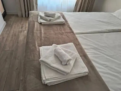 two towels are sitting on top of a bed at Infinity Park Apartment in Sandanski