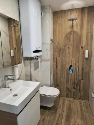 a bathroom with a shower and a toilet and a sink at Infinity Park Apartment in Sandanski