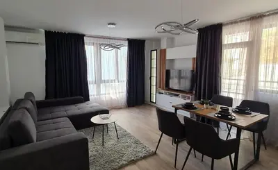 a living room with a couch and a table with chairs at Infinity Park Apartment in Sandanski
