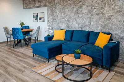 a living room with a blue couch and a table at Апартамент за Гости Танчеви in Karlovo