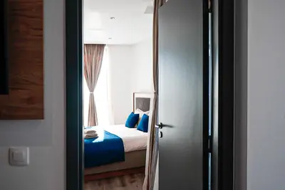 a bedroom with a bed with blue pillows and a window at Апартамент за Гости Танчеви in Karlovo