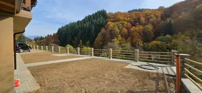 a fence on the side of a road with a mountain at Къща за гости 'Кадийца' in Sushitsa