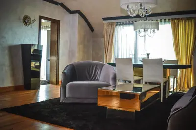 a living room with a chair and a table at Capital City Center Apart Residence in Plovdiv
