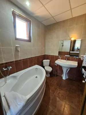 a bathroom with a tub and a sink and a toilet at Family Hotel Jeri in Velingrad