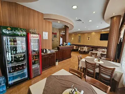 a restaurant with a soda machine and tables and chairs at Family Hotel Jeri in Velingrad