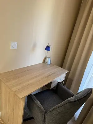a wooden desk with a lamp and a chair at Guest Apartment Elina in Smolyan
