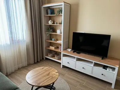 a living room with a flat screen tv on a white cabinet at Guest Apartment Elina in Smolyan