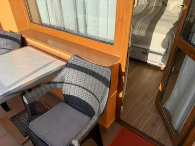 a room with a table and a chair next to a window at Guest Apartment Elina in Smolyan