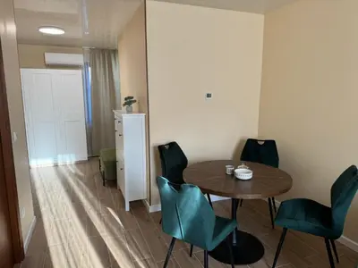 a dining room with a table and green chairs at Guest Apartment Elina in Smolyan