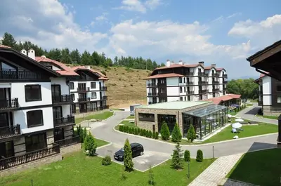 arial view of a building with a parking lot and cars at Sun and view cozy apartment in Razlog