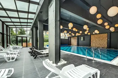 a pool with white lounge chairs and a swimming pool at Sunny Mountain View apartment in Razlog