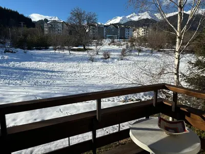 a bench on a balcony with a snow covered field at Green life Bansko -view one bedroom apartment in Bansko