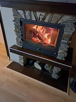 a fireplace in a living room with a fire in it at Green life Bansko -view one bedroom apartment in Bansko