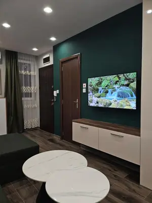 a living room with two tables and a flat screen tv at Boutique apartment green 2 in Plovdiv