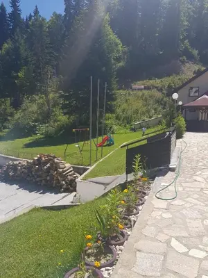 a backyard with a garden with flowers and a playground at Holiday home with indoor fireplace in Pamporovo