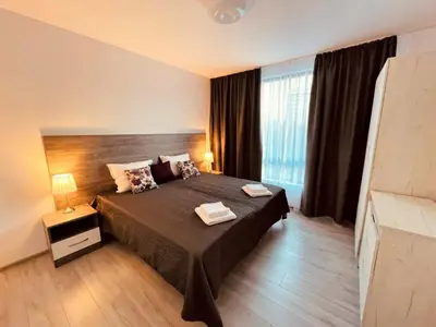 a bedroom with a large bed and a large window at Apart2bedroomslux in Sofia