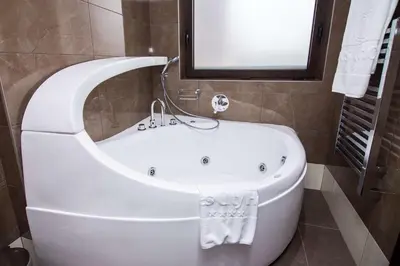 a white bath tub in a bathroom with a window at Best Western Plus Olives City Hotel - Free Pool & Parking in Sofia