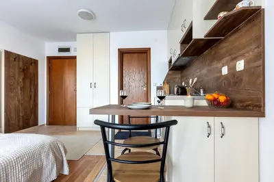 a kitchen with a counter with two chairs in a room at Divine mountain studio - parking - SPA in Bansko
