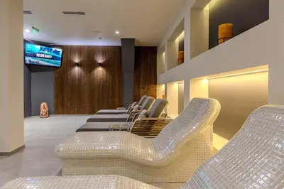 a waiting room with white chairs and a television at Divine mountain studio - parking - SPA in Bansko