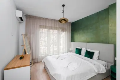 a bedroom with a large bed with a green wall at Sunny Stylish Apartment in Sofia by Flat Mаnager in Sofia