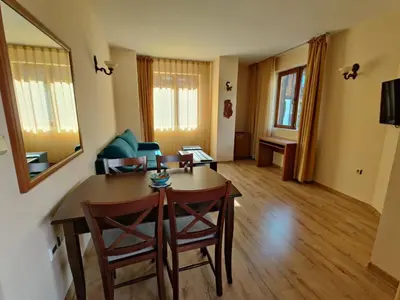 a living room with a table and a couch at Fenix Emerald in Bansko