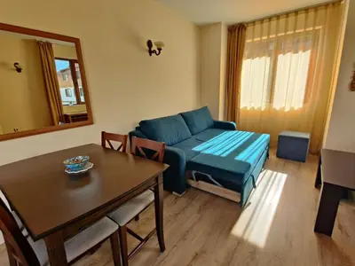 a living room with a blue couch and a table at Fenix Emerald in Bansko