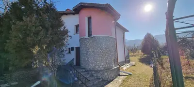 a small pink and white house with a stone wall at BoroVille in Raduil