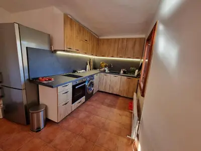 a small kitchen with wooden cabinets and a refrigerator at BoroVille in Raduil