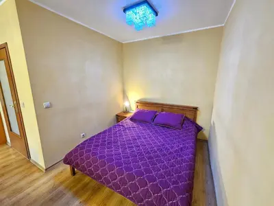 a bedroom with a purple bed with a purple comforter at Two charming Studios in Trinity Bansko with balcony and free parking by Flat Mаnager in Bansko