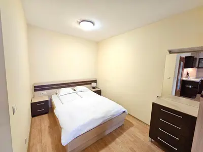 a bedroom with a bed and a dresser in it at Two charming Studios in Trinity Bansko with balcony and free parking by Flat Mаnager in Bansko