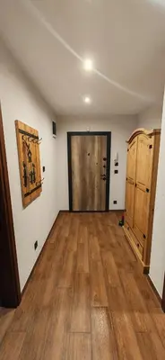 an empty room with a large door and wooden floors at Rhodopski Apartment in Chepelare