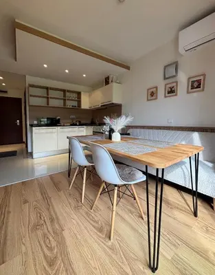a kitchen and dining room with a wooden table and chairs at TERRA Vista Penthouse near Pirin Golf and Bansko in Razlog