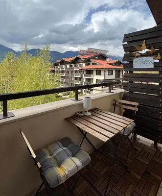 a bench on a balcony with a view of a building at TERRA Vista Penthouse near Pirin Golf and Bansko in Razlog