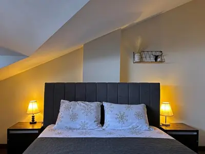 a bedroom with a large bed with two lamps on tables at TERRA Vista Penthouse near Pirin Golf and Bansko in Razlog