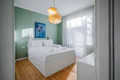 a bedroom with a white bed and a chandelier at Charming 1BD Apartment Next to Women's Market by Flat Mаnager in Sofia