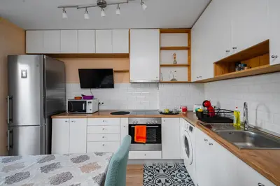 a kitchen with white cabinets and a stainless steel refrigerator at Charming 1BD Apartment Next to Women's Market by Flat Mаnager in Sofia