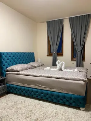 a bedroom with a blue bed with a blue headboard at JMN Pamporovo in Pamporovo