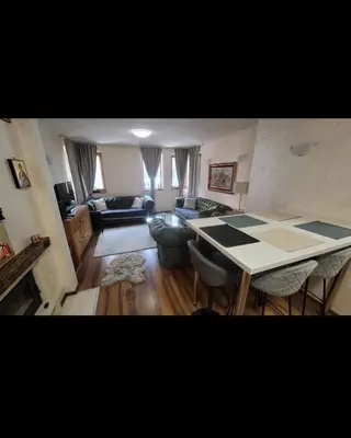 a living room with a table and a couch at JMN Pamporovo in Pamporovo