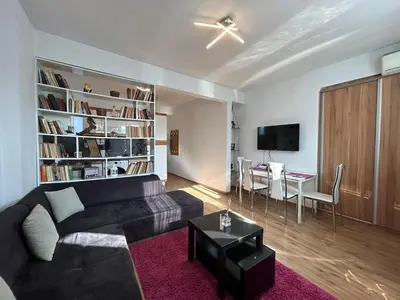 a living room with a black couch and a table at Cozy Stay Sofia Historic Center in Sofia