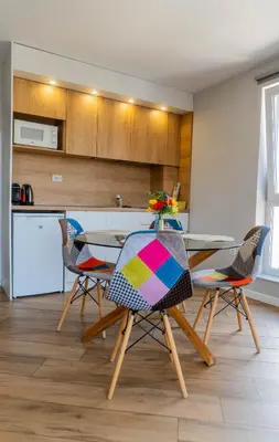 a kitchen with a table and chairs in a room at Апартамент с люлка и гледка в The House с Термална зона in Velingrad
