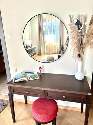 a table with a red chair and a mirror at Alpine Charm Borovets Apart in Borovets