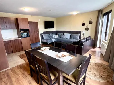 a living room with a table and a couch at Slope nest Bansko in Bansko
