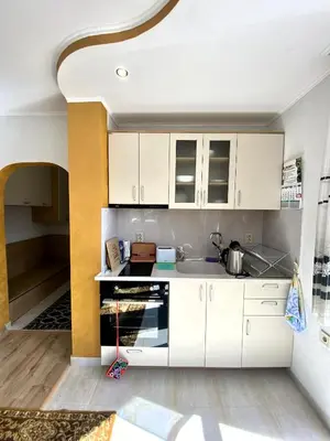 a kitchen with white cabinets and a sink at Апартамент и Студио Перелик in Chepelare