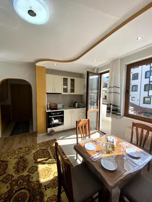 a kitchen and dining room with a table and chairs at Апартамент и Студио Перелик in Chepelare